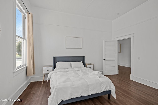 bedroom with baseboards and wood finished floors