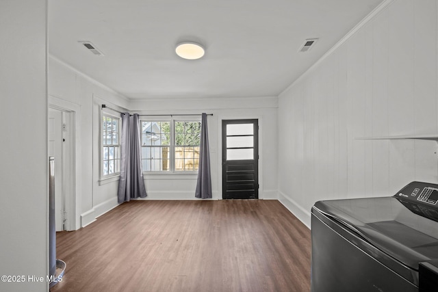 interior space with washer / dryer, visible vents, ornamental molding, and wood finished floors