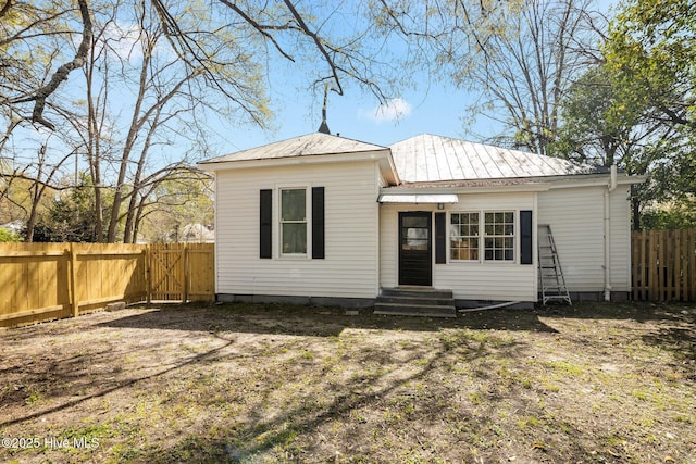 view of front of property with entry steps, metal roof, a gate, and fence private yard