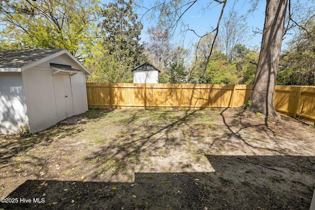 view of yard featuring an outbuilding, a storage unit, and a fenced backyard