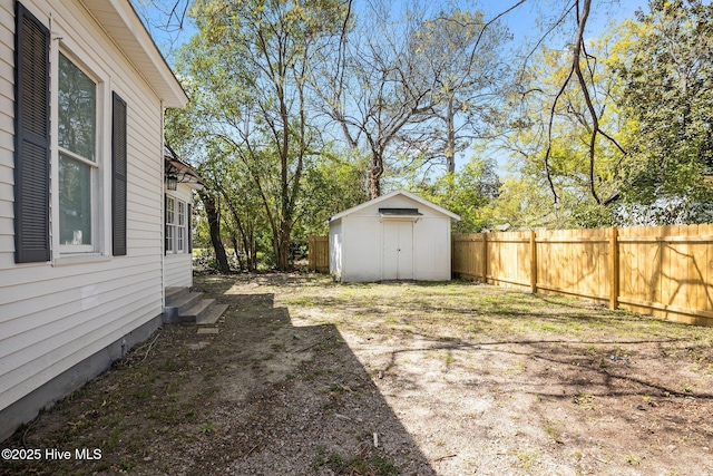 view of yard featuring a fenced backyard, entry steps, a storage shed, and an outdoor structure