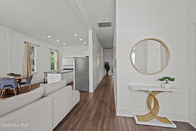 living room featuring baseboards, dark wood finished floors, visible vents, and recessed lighting