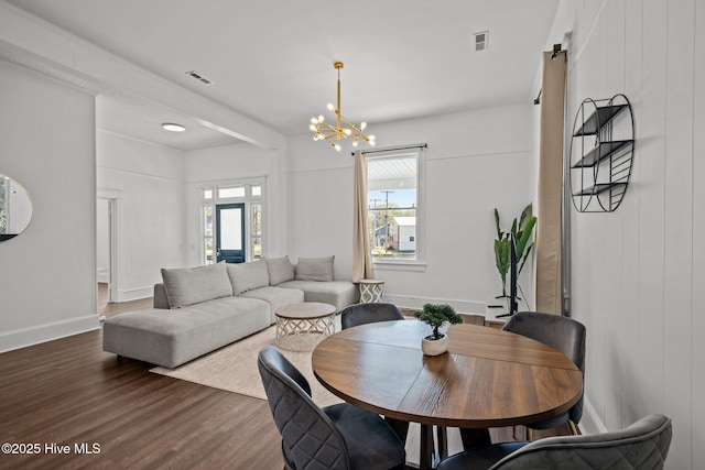 dining room featuring dark wood-style flooring, visible vents, baseboards, and a chandelier