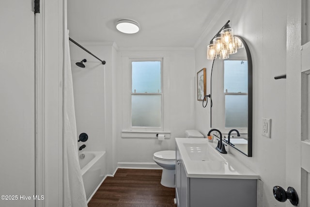 bathroom featuring baseboards, ornamental molding, toilet, vanity, and wood finished floors