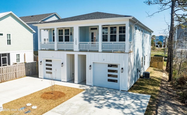 1205 Mackerel Ln Unit 2, Carolina Beach, NC 28428 - view of front facade featuring an attached garage, board and batten siding, fence, cooling unit, and concrete driveway
