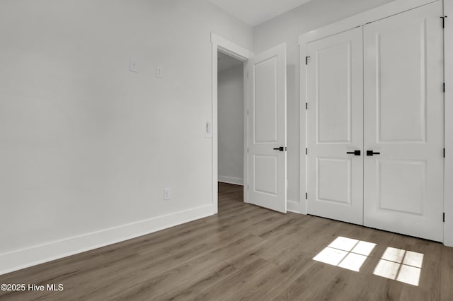 1205 Mackerel Ln Unit 2, Carolina Beach, NC 28428 - unfurnished bedroom with a closet, baseboards, and wood finished floors