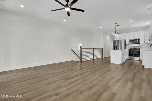 1205 Mackerel Ln Unit 2, Carolina Beach, NC 28428 - unfurnished living room featuring ceiling fan, light wood finished floors, recessed lighting, and baseboards