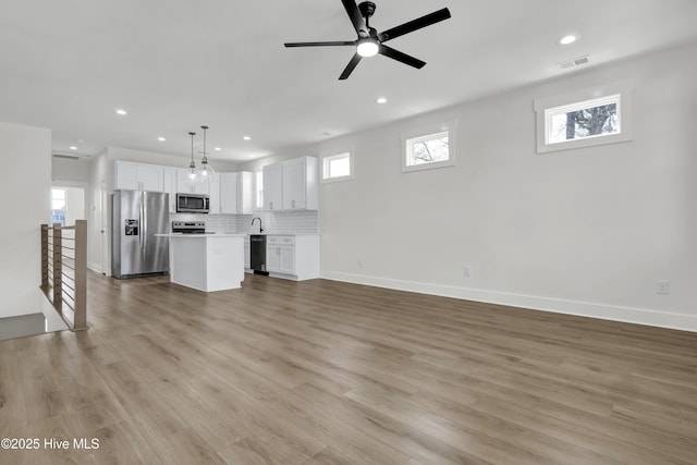 1205 Mackerel Ln Unit 2, Carolina Beach, NC 28428 - unfurnished living room with visible vents, baseboards, ceiling fan, light wood-type flooring, and recessed lighting