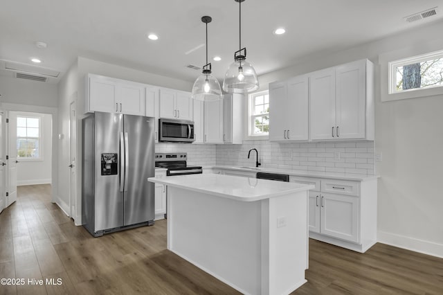 1205 Mackerel Ln Unit 2, Carolina Beach, NC 28428 - kitchen with a wealth of natural light, white cabinetry, a sink, and appliances with stainless steel finishes