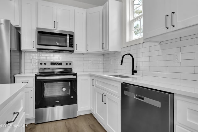 1205 Mackerel Ln Unit 2, Carolina Beach, NC 28428 - kitchen featuring a sink, light wood-type flooring, light countertops, and appliances with stainless steel finishes
