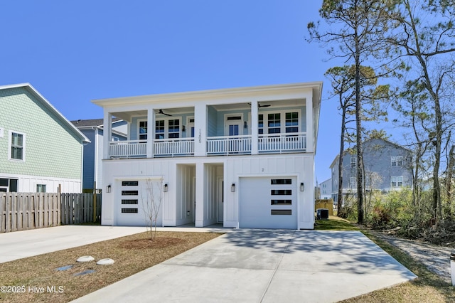 1205 Mackerel Ln Unit 2, Carolina Beach, NC 28428 - view of front of property with board and batten siding, ceiling fan, fence, a garage, and driveway