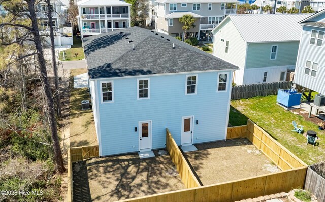 1205 Mackerel Ln Unit 2, Carolina Beach, NC 28428 - back of property featuring cooling unit, roof with shingles, a fenced backyard, and a residential view