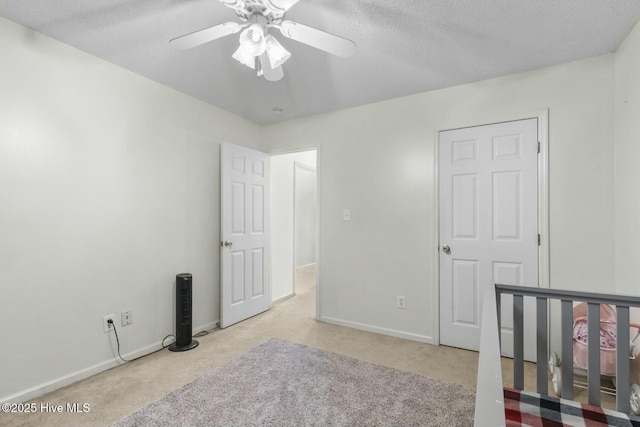 bedroom with carpet, baseboards, a textured ceiling, and ceiling fan