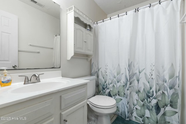 full bath with visible vents, toilet, vanity, and a textured ceiling