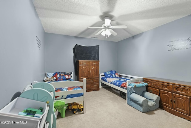 bedroom featuring carpet floors, ceiling fan, and a textured ceiling