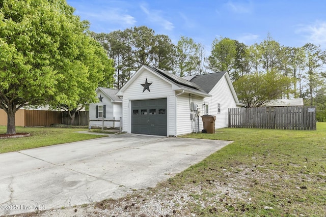 view of property exterior with roof mounted solar panels, fence, and a lawn