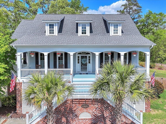 view of front of house with a porch, stairway, and roof with shingles