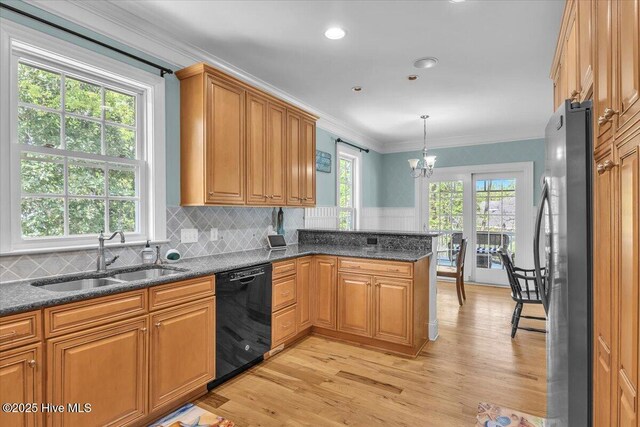 kitchen with a chandelier, freestanding refrigerator, black dishwasher, light wood-style floors, and a sink