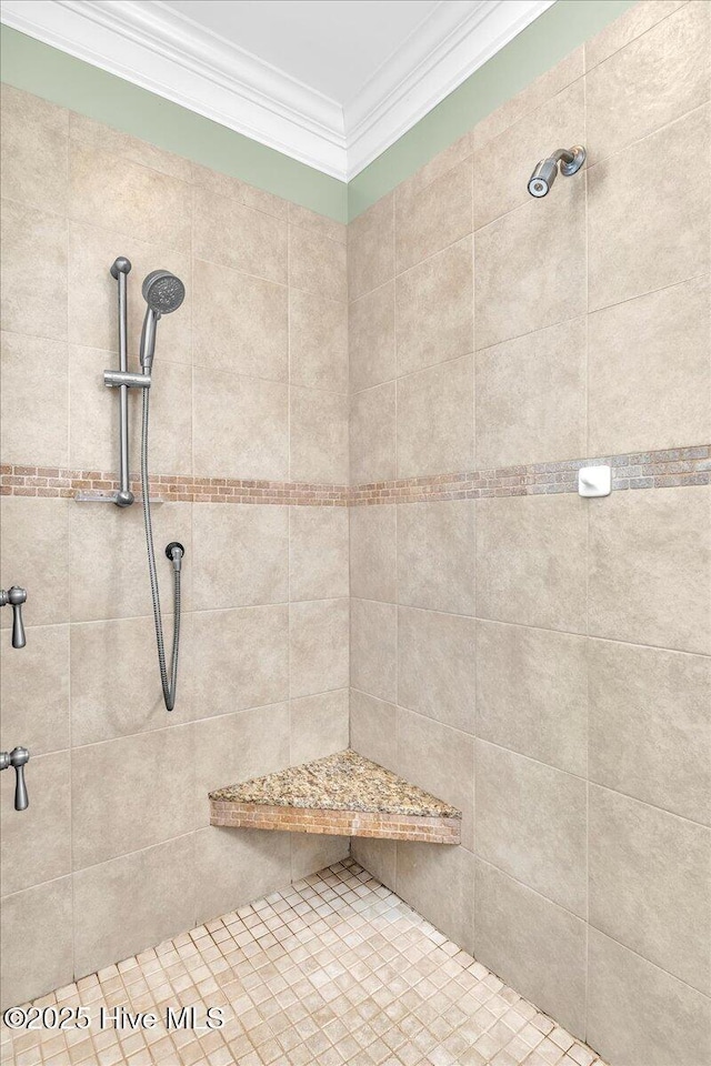 full bathroom with a tile shower and ornamental molding