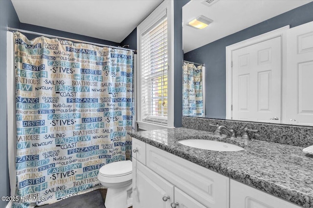 bathroom with toilet, vanity, and a shower with curtain