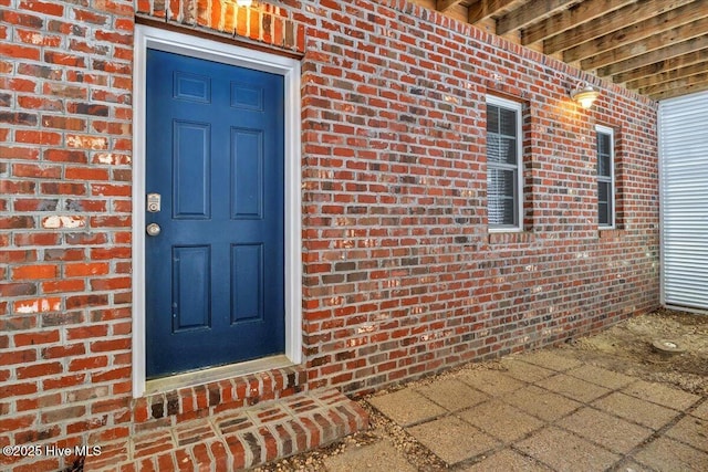 doorway to property with brick siding