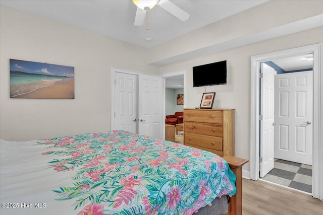 bedroom featuring a closet, light wood finished floors, ceiling fan, and baseboards