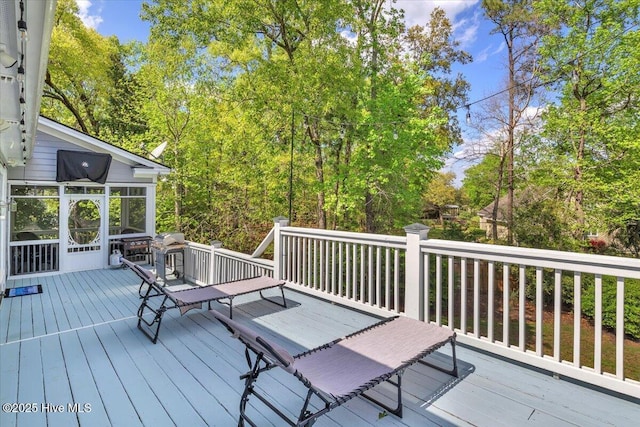 wooden deck with a sunroom