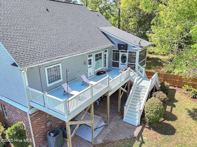 back of house with central air condition unit, a shingled roof, a sunroom, and a wooden deck