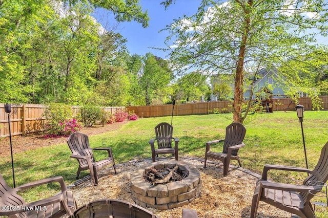 view of yard featuring a fire pit and a fenced backyard