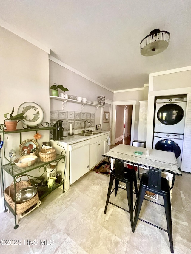interior space with stacked washer / dryer and ornamental molding