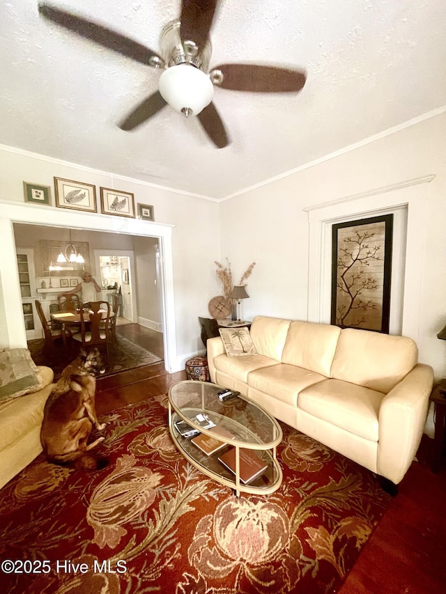 living room featuring ornamental molding, a ceiling fan, and wood finished floors