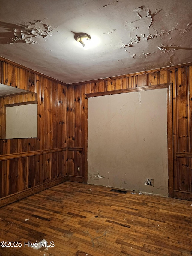 basement with wooden walls and hardwood / wood-style flooring