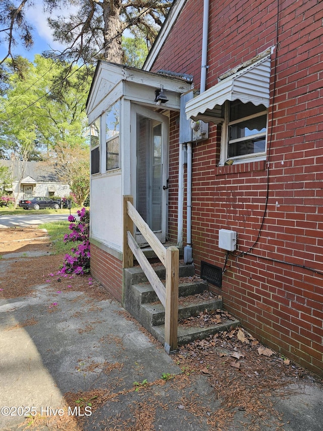 view of exterior entry with brick siding