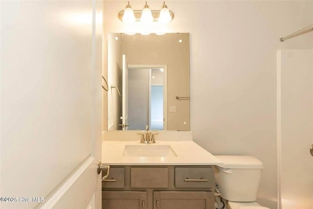 bathroom with walk in shower, toilet, and vanity