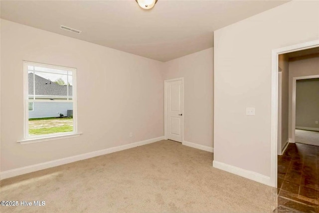 carpeted empty room featuring visible vents and baseboards