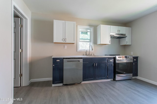 915 N Broad St, Edenton, NC 27932 - kitchen featuring appliances with stainless steel finishes, a sink, light wood-style flooring, under cabinet range hood, and baseboards