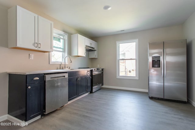 915 N Broad St, Edenton, NC 27932 - kitchen featuring appliances with stainless steel finishes, a sink, under cabinet range hood, light wood-style floors, and baseboards