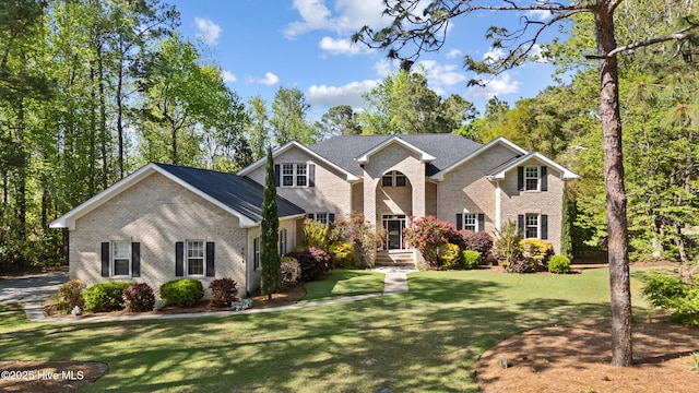 traditional-style house featuring a front yard and brick siding