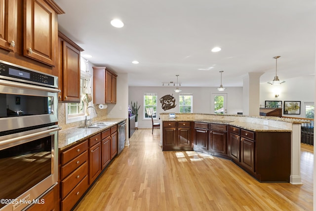 kitchen with tasteful backsplash, recessed lighting, stainless steel appliances, light wood finished floors, and a sink
