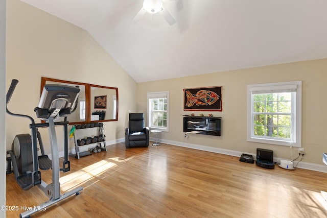 exercise area with wood finished floors, ceiling fan, baseboards, and vaulted ceiling
