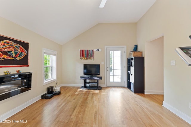 living area with ceiling fan, baseboards, wood finished floors, and lofted ceiling