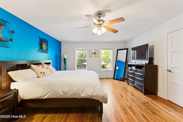 bedroom featuring ceiling fan, light wood-type flooring, and baseboards