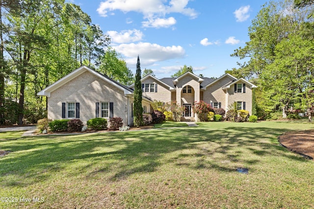 traditional-style house featuring a front yard and brick siding