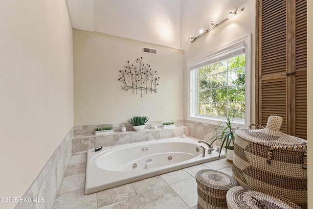bathroom with tile patterned floors, a whirlpool tub, and visible vents