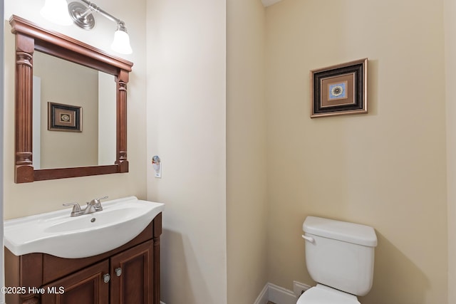 bathroom with vanity, baseboards, and toilet