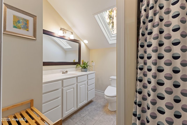 full bathroom featuring vaulted ceiling with skylight, vanity, a shower with curtain, toilet, and tile patterned floors