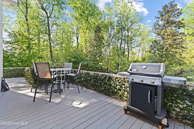 deck with outdoor dining area and a grill