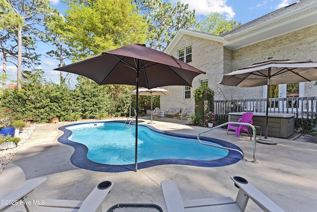 outdoor pool featuring a patio area and a jacuzzi