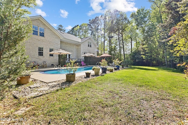 outdoor pool featuring a patio, a yard, and fence