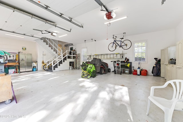 garage featuring a garage door opener and stainless steel fridge